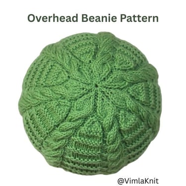 Top view of a green knitted cable beanie, showing the crown shaping and intertwined cable patterns.
