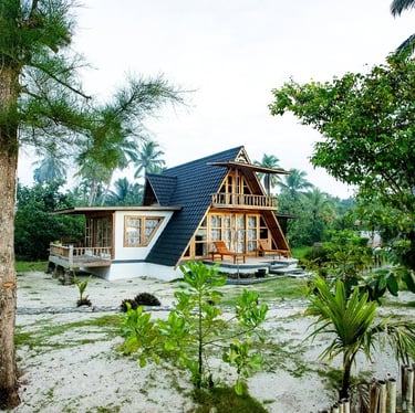 a house with a triangle shaped roof and a wooden fence
