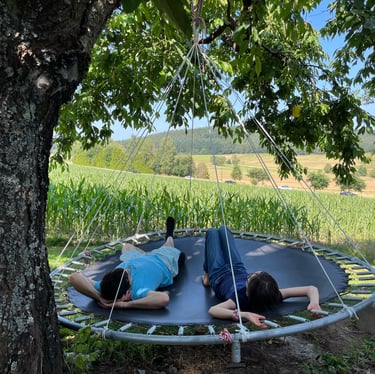 a man and woman laying on a hanging bed