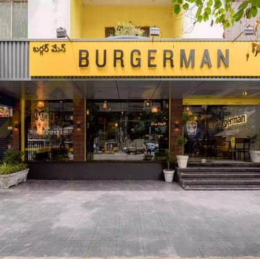 a restaurant with a large yellow sign that says burgerman