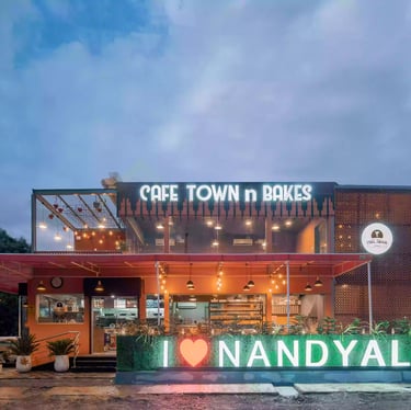 a cafe and bakery with a neon sign that says Cafe Town n Bakes