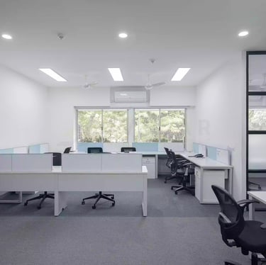 a office room with a workstation desks and chairs and a window