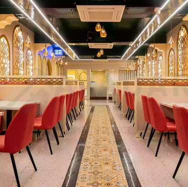 a restaurant with red chairs and white tables and Mughal arches