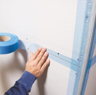 a person holding a tape tape and tape tape on a wall