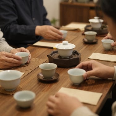 Close-up of a steaming cup of green tea beside loose tea leaves on a dark wooden table.