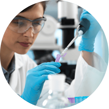 a woman in a lab coat and gloves holding a pipe of liquid