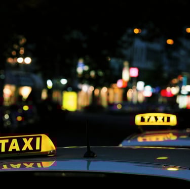 Taxi sign on a black roof of a vehicle