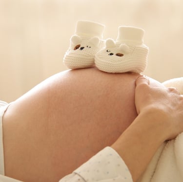 Barriga de embarazada con patucos encima