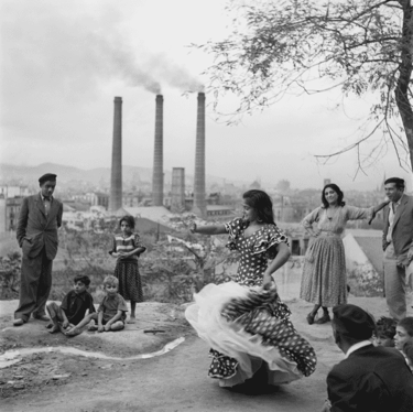 Una fotografía antigua en blanco y negro de una bailaora de flamenco frente a las tres chimeneas