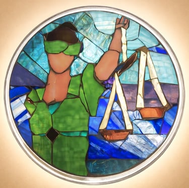 Stained glass mosaic of 'Lady Justice" featuring vibrant cool colored tesserae.