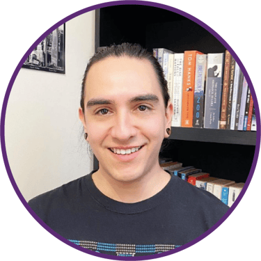 a man with a smile on his face and a bookcase in front of a