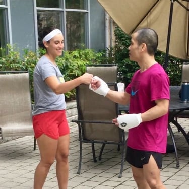 a man and woman holding hands and shaking hands after martial arts training outside