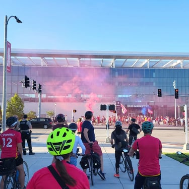 Large shot of a biking event with pink smoke in the air