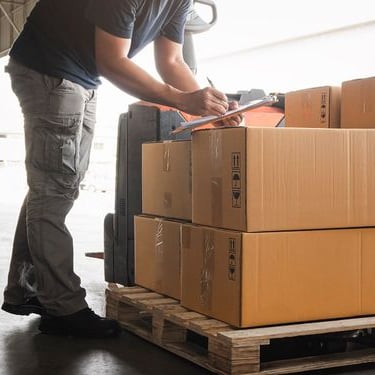 a man is standing in front of a stack of boxes