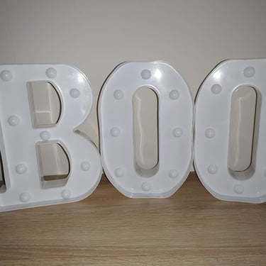 White LED marquee letters spelling "BOO" with glitter finish, perfect Halloween decoration for home,