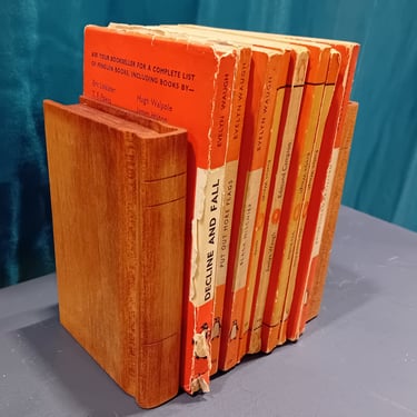Pail of book-shaped wooden bookends around a set of orange books