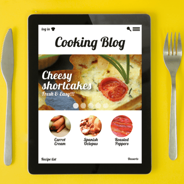 Photo of a tablet between a knife and fork. Tablet says "Cooking Blog"