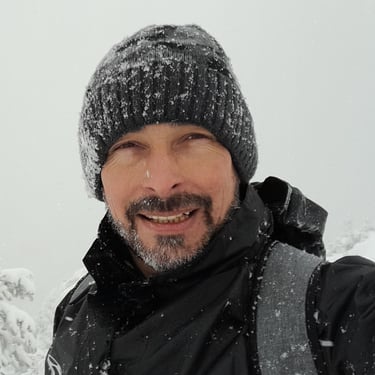 a man in a black jacket and a hat on a snowy day