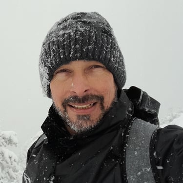 a man in a black jacket and a hat on a snowy day