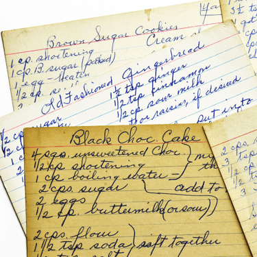 Photo of several yellowed recipe cards with handwritten recipes on them