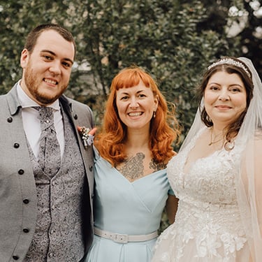 Sommer Hochzeit! Ein traumhaftes curvy Hochzeitspaar, das nach der Trauung in die Kamera strahlt.