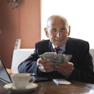 retired individual holding money symbolizing his retirement savings and wealth