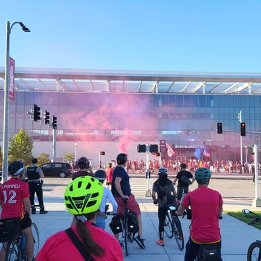 Large shot of a biking event with pink smoke in the air