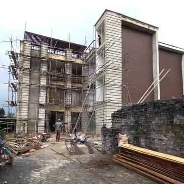 A modern commercial building under construction with metal scaffolding and stacked building materials.