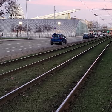 Light rail train tracks next to a road
