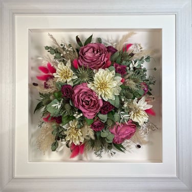 Birdseye view preserved wedding bouquet with bold magenta dried bunny tails in a frame