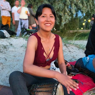 Georgina smiling playing Djembe African Drum. Photo by Kirill Shulepov