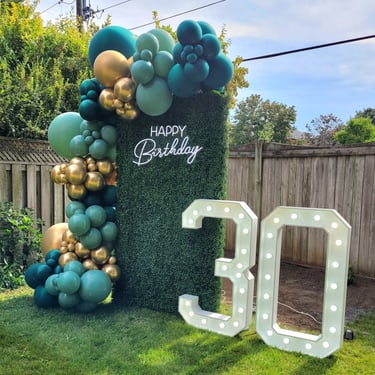30th marquee with green & gold balloons