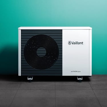 a white and black heat pump with a green wall