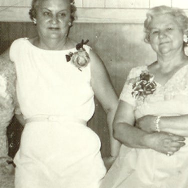 a group of women sitting on a bench in a room