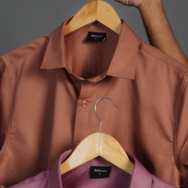 a man holding a hanger with a hanger of a shirt on it