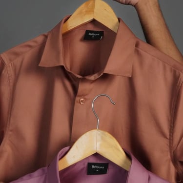 a man holding a hanger with a hanger of a shirt on it