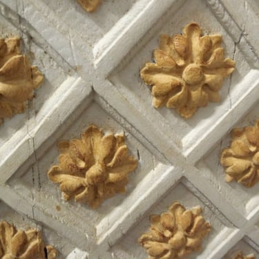 Fleurs de lys sculptées en bois et peintes sur un buffet d'époque