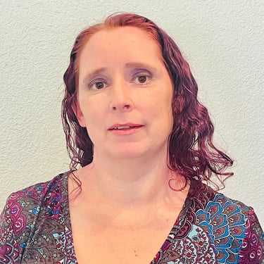 a woman with red hair and a patterned shirt
