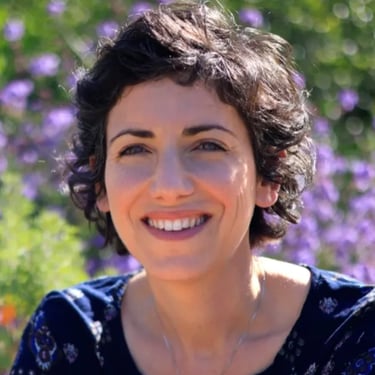 Jane Sterken smiling in field of flowers