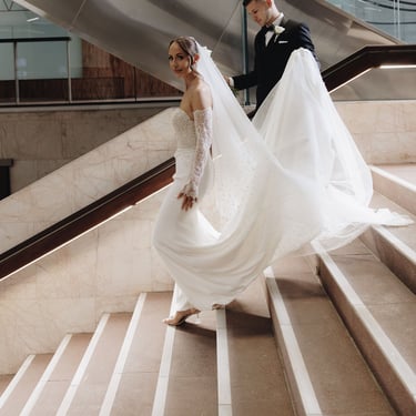 a bride and groom walking down a flight of stairs