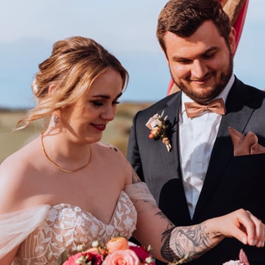 Ringtausch. die tätowierte Braut greift nach dem Ehering um diesen ihrem Bräutigam anzustecken. er lächelt glücklich