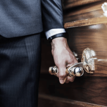 a close up of a pall bearer holding a coffin's handle