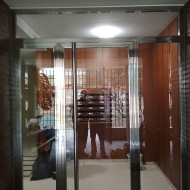 Entrada bloque de pisos. Puerta de acero inoxidable acabado brillo en Sevilla