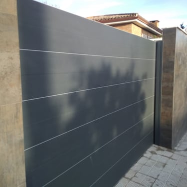 Puerta entrada vehículos motorizada. Hierro y chapa galvanizada lacada.