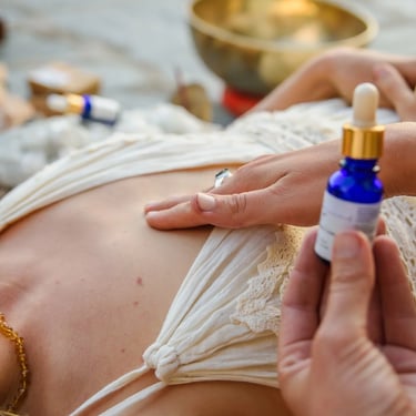 Holistic practitioner applying essential oils to a client during a spiritual sound healing session.