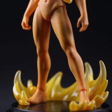 Close-up of a limited edition resin statue, dramatic lighting casting sharp shadows, yellow energy effects, dark background.