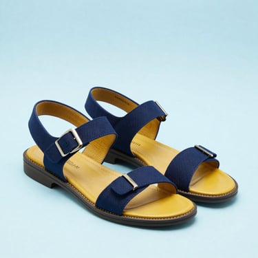 Crisp studio shot of elegant Paragon men's formal sandals on a clean light blue background, professional commercial lighting
