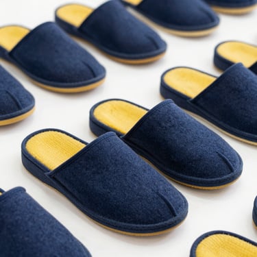 Classic durable Paragon blue and yellow slippers on a clean surface, sharp commercial focus