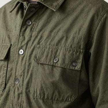Close-up of a heavy cotton utility jacket showing precise double-needle stitching and custom flat-felled seams.