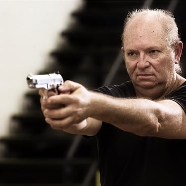 David-Graham Parker aiming a pistol